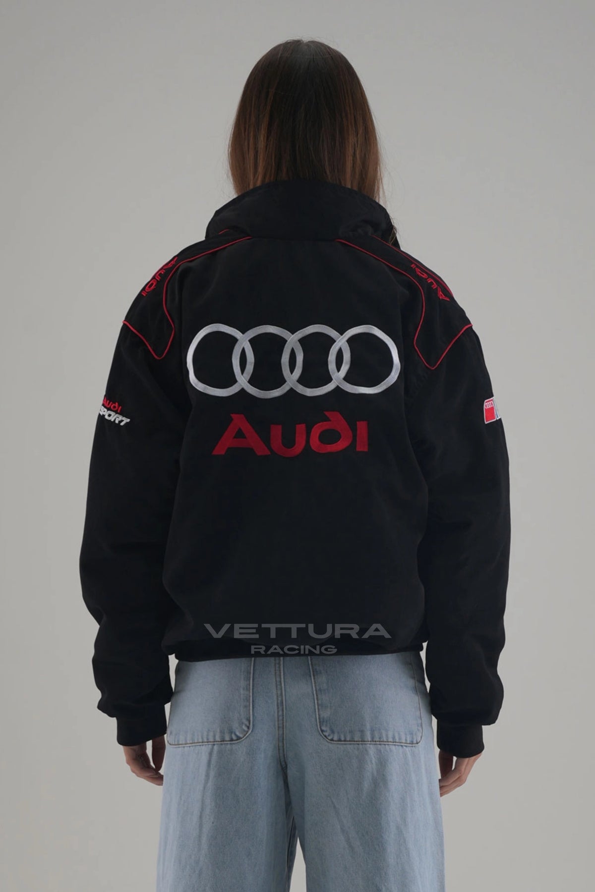 Rear view of the Audi vintage racing jacket worn with wide leg jeans