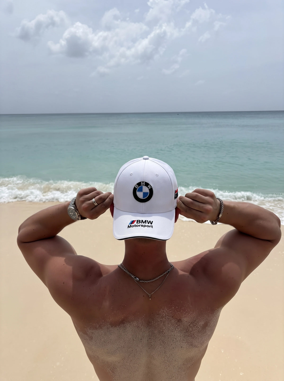 White BMW Motorsport cap worn at the beach