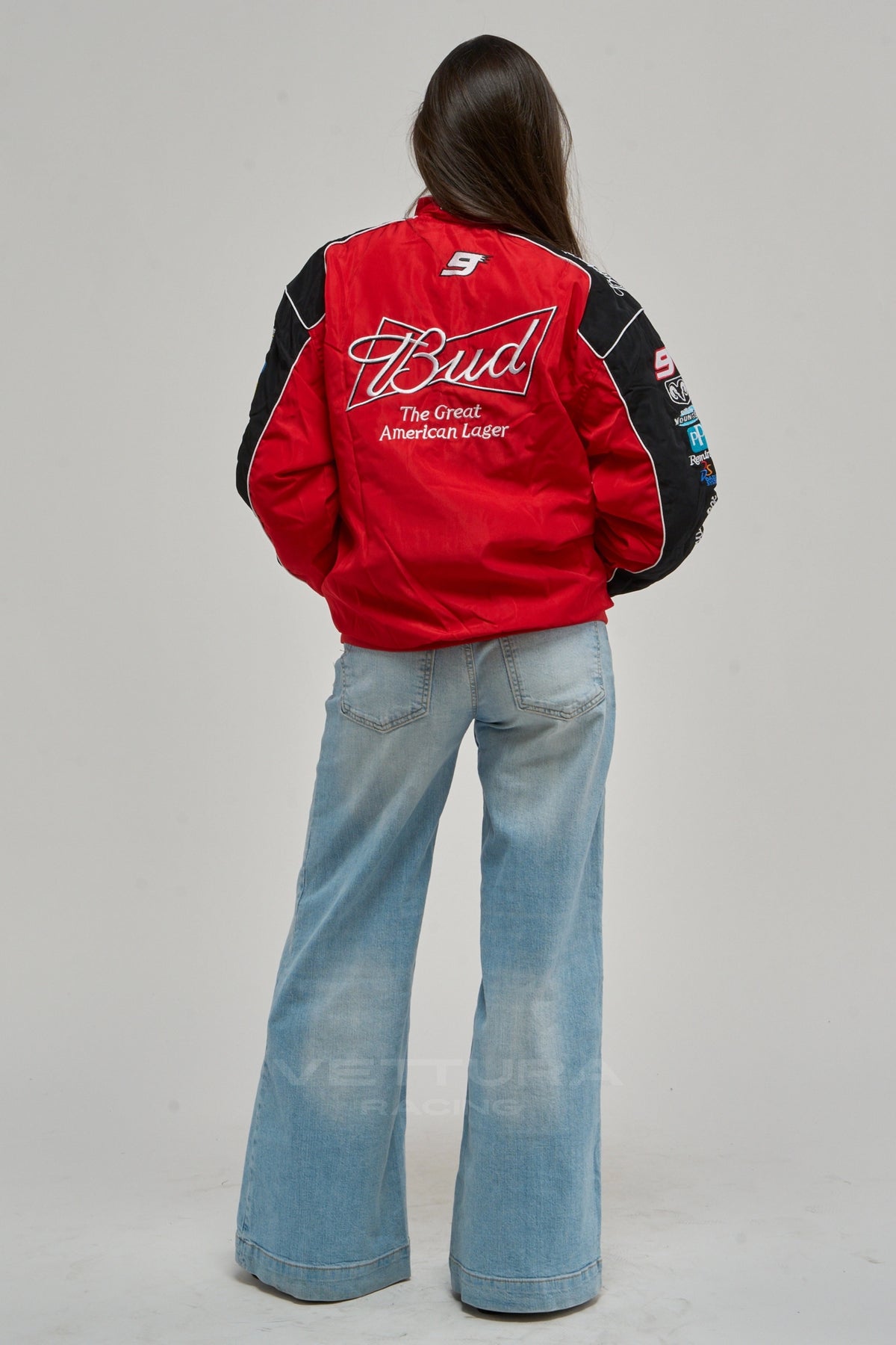 Rear view of the red Budweiser NASCAR bomber worn with wide leg jeans