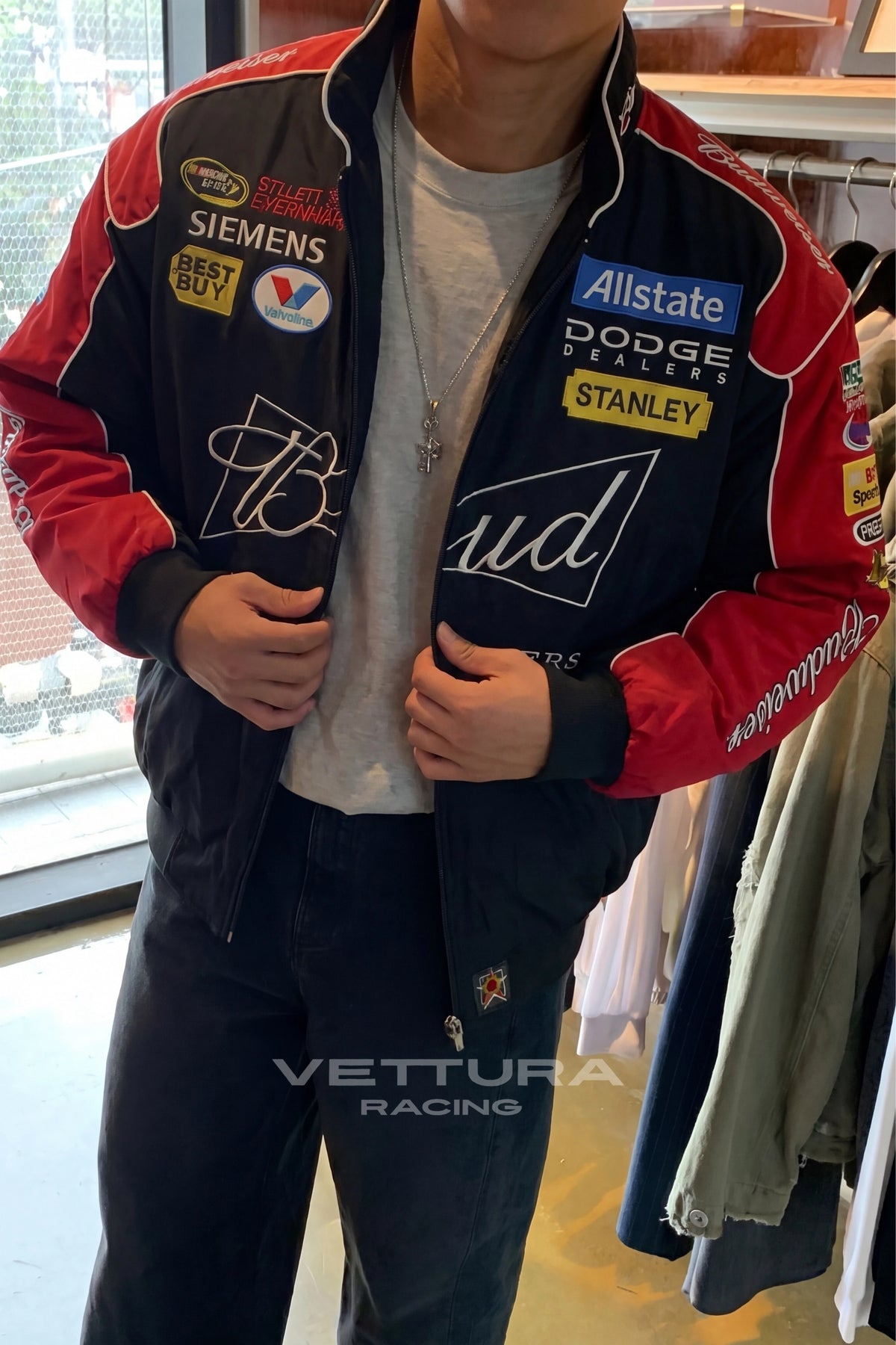 Outdoor lifestyle shot of the black Budweiser NASCAR racing jacket