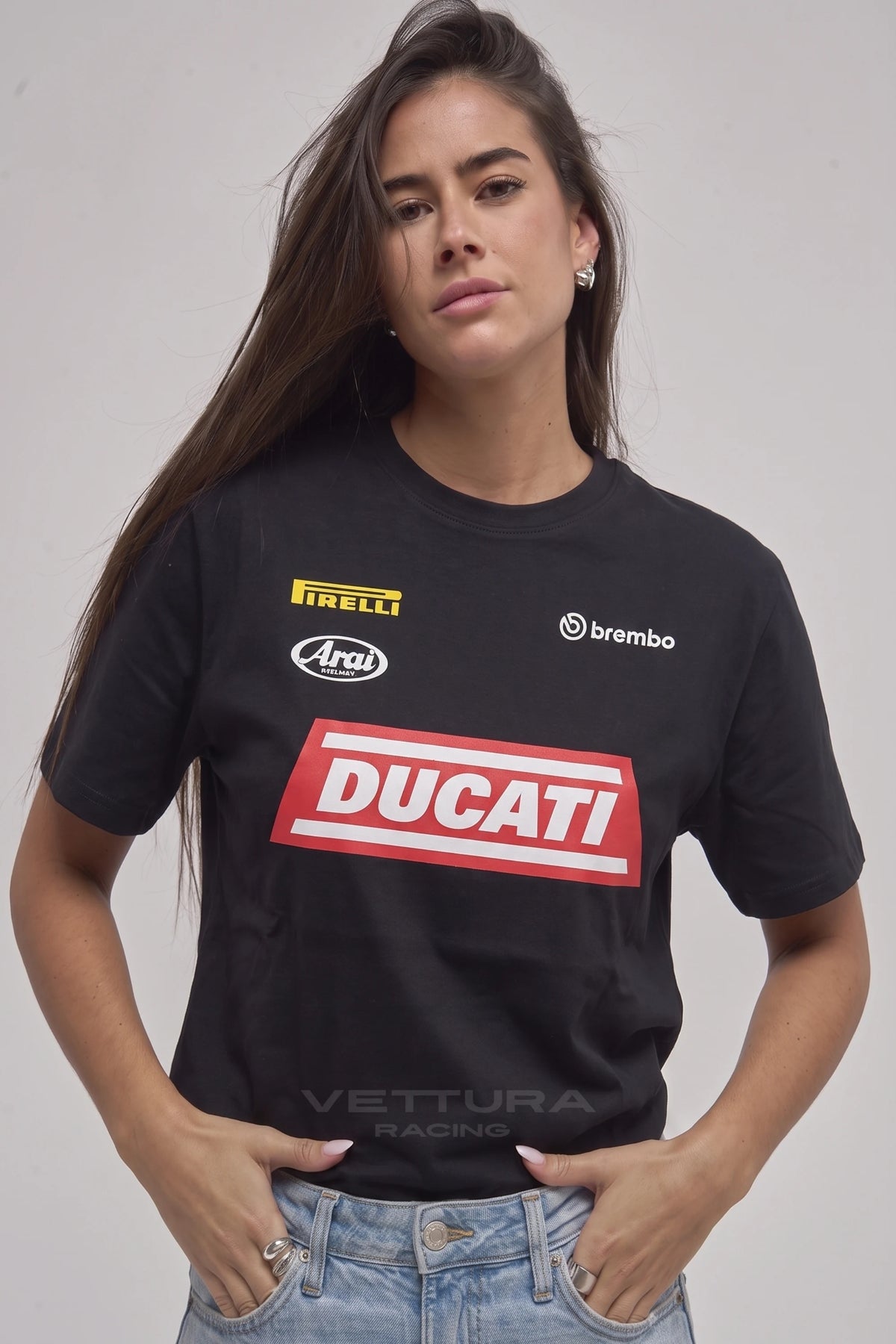 Woman wearing the Ducati racing t-shirt in black, front view with the Pirelli, Arai and Brembo prints