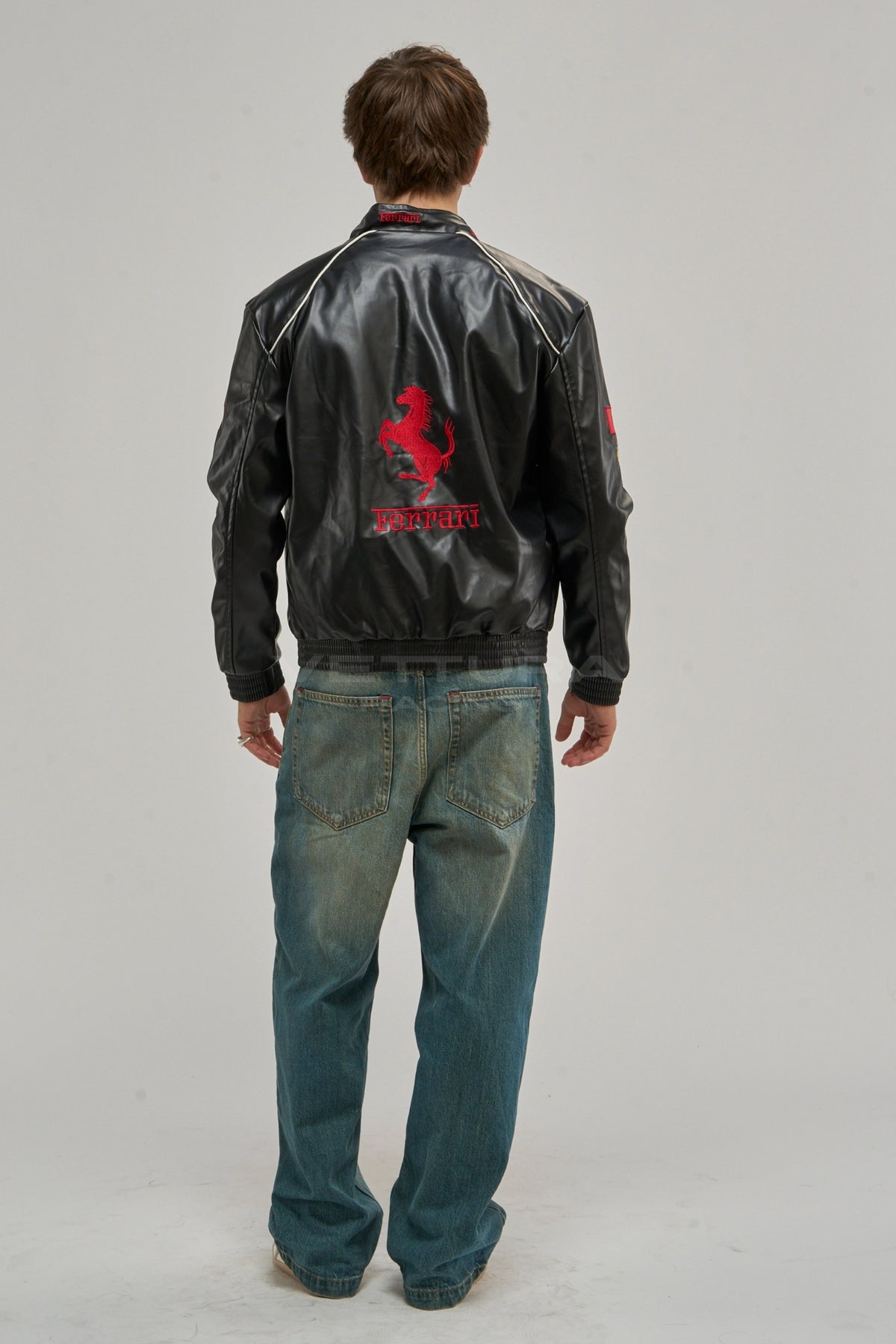 Model wearing the Ferrari F1 vegan leather jacket, front view with the red Ferrari block