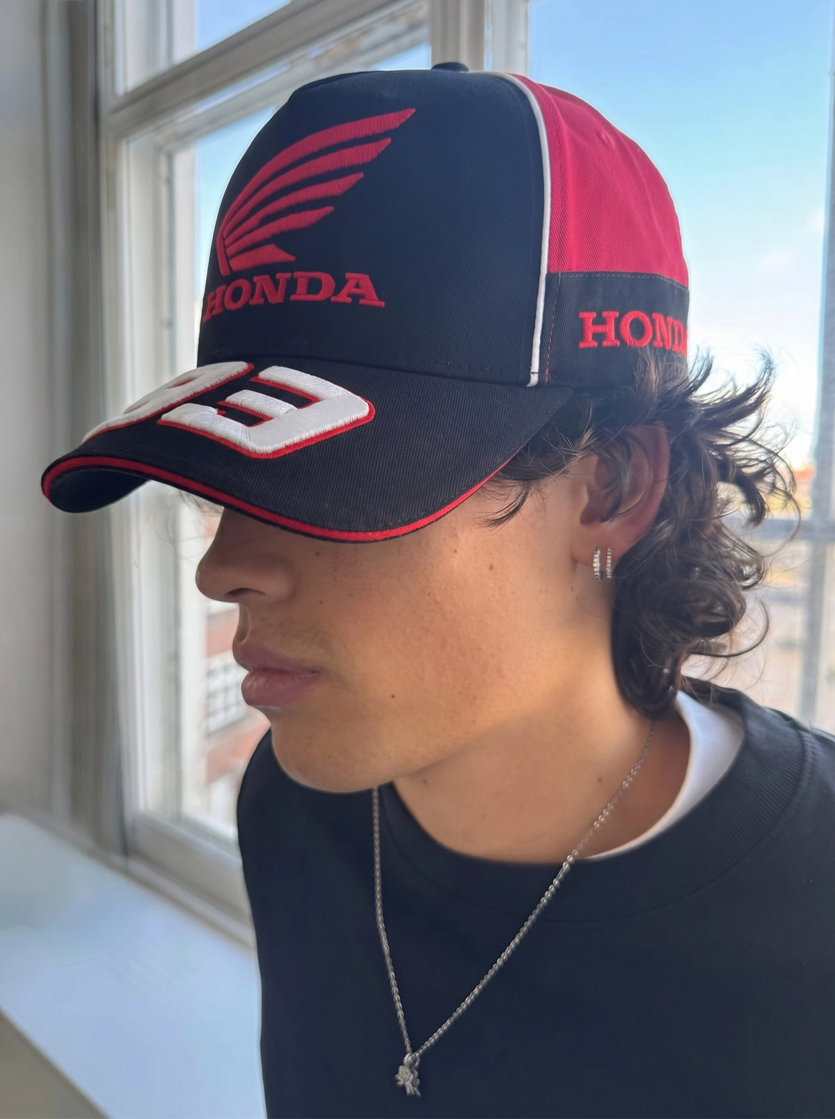 Honda 93 racing cap worn indoors