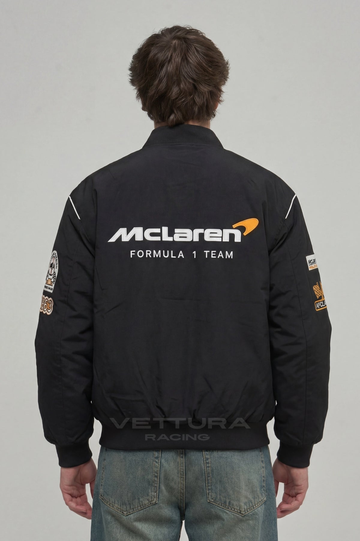Model wearing the McLaren F1 Team racing jacket in black, front view