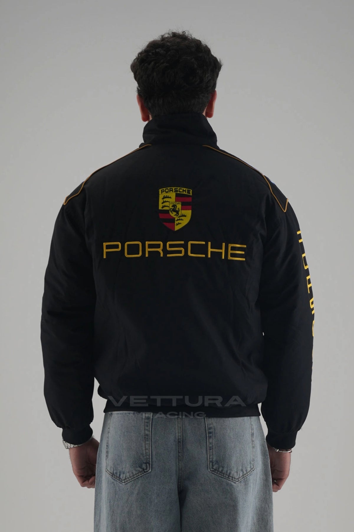 Back of the black Porsche vintage racing jacket on a model