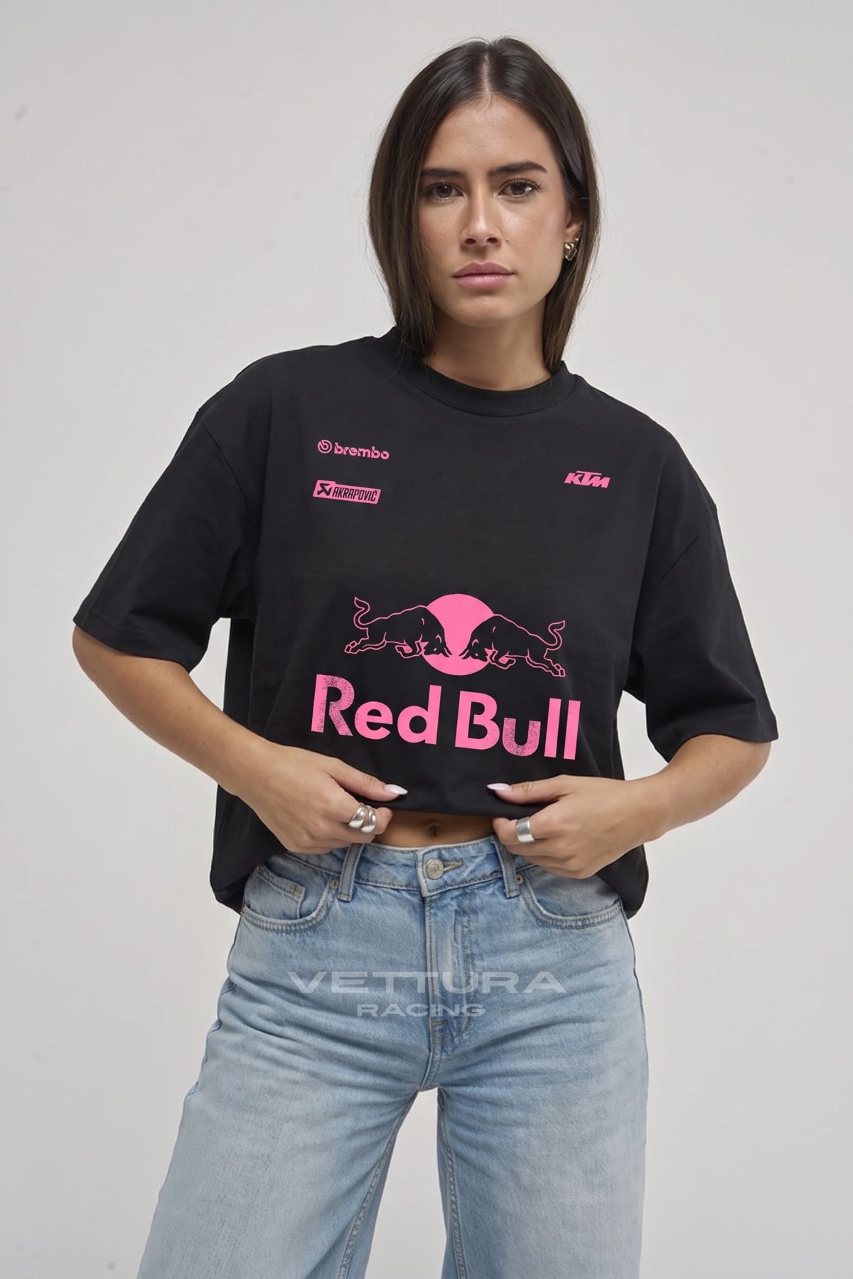 Woman wearing the Red Bull racing t-shirt pink edition, front view with the pink Red Bull print