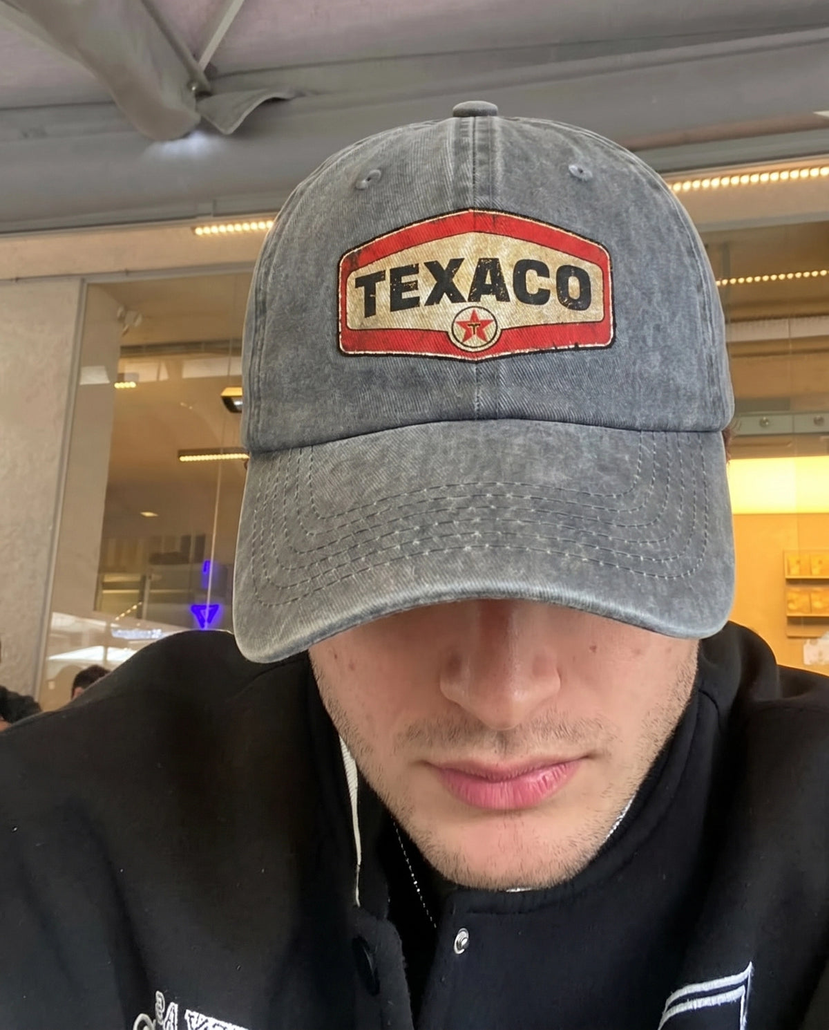 Black Texaco Motor cap worn indoors