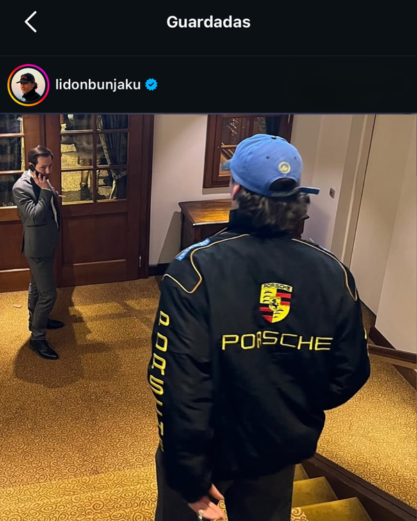 Back view of a man in a black and yellow Porsche vintage racing jacket