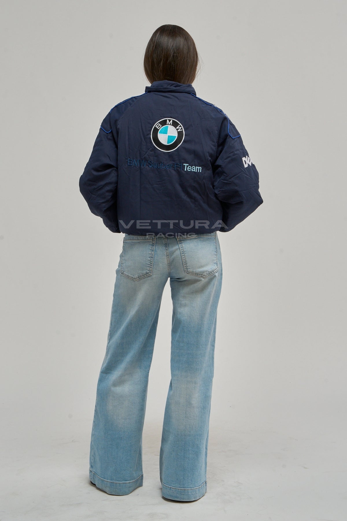 Rear view of the BMW Petronas racing bomber worn with wide leg jeans
