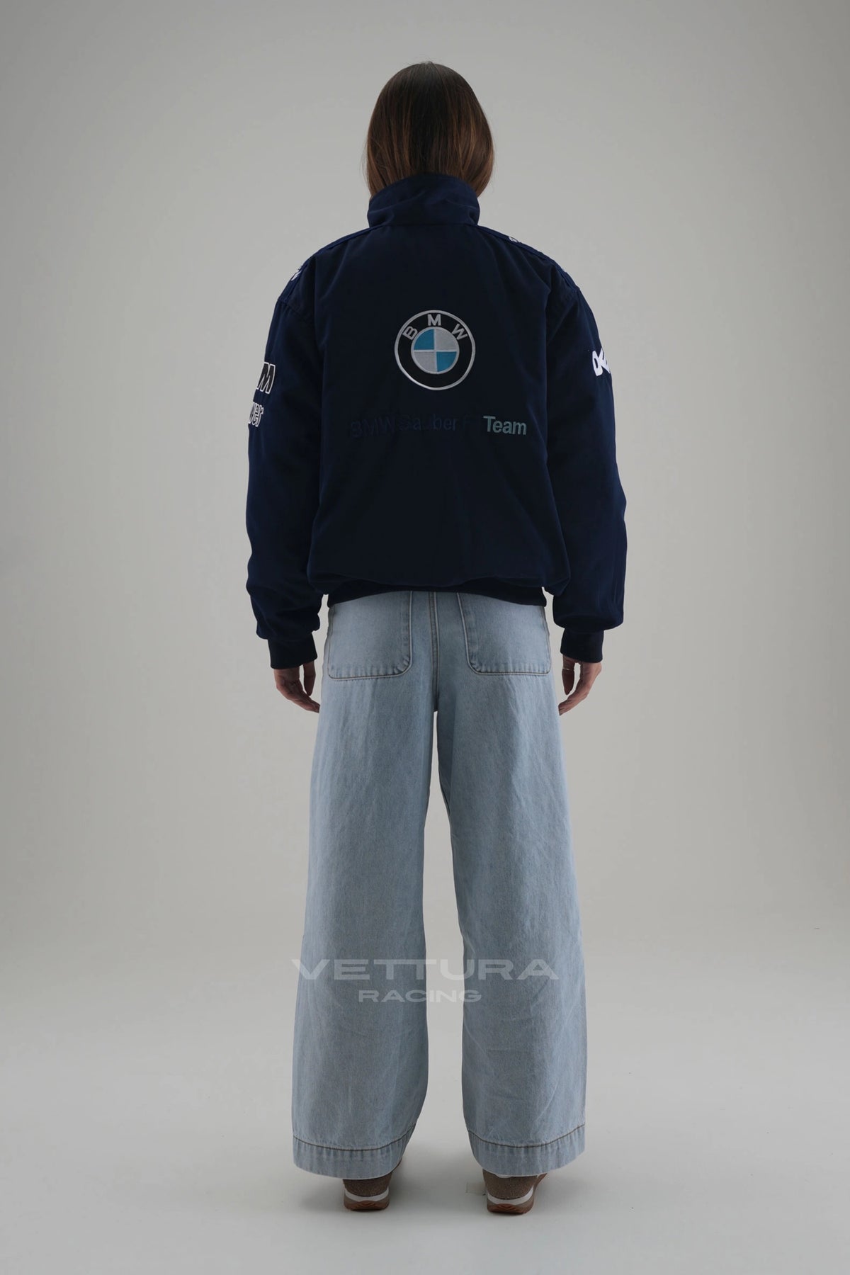 Rear view of the BMW M Power racing bomber worn with wide leg jeans