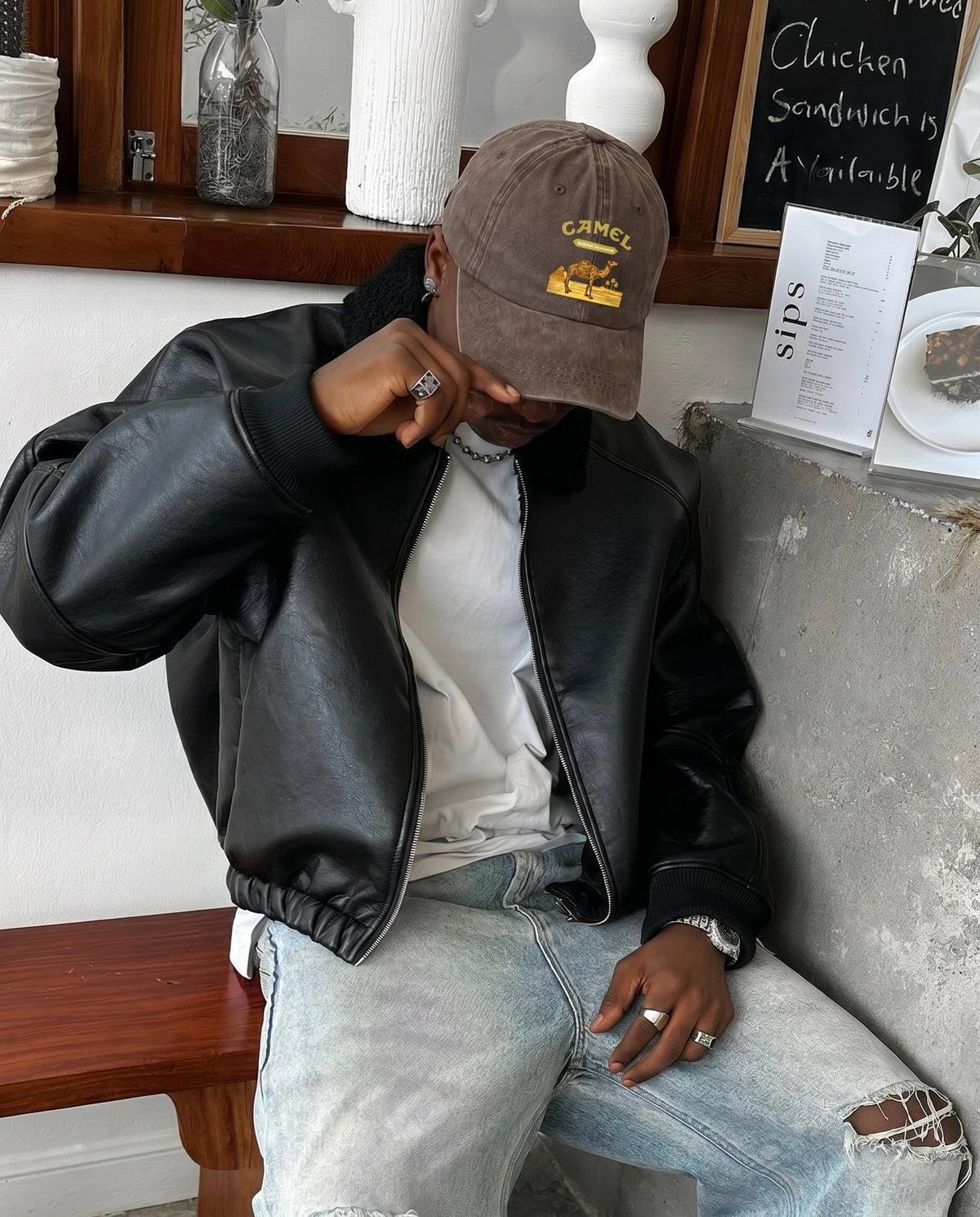 Model wearing the brown Camel Desert cap with a leather jacket