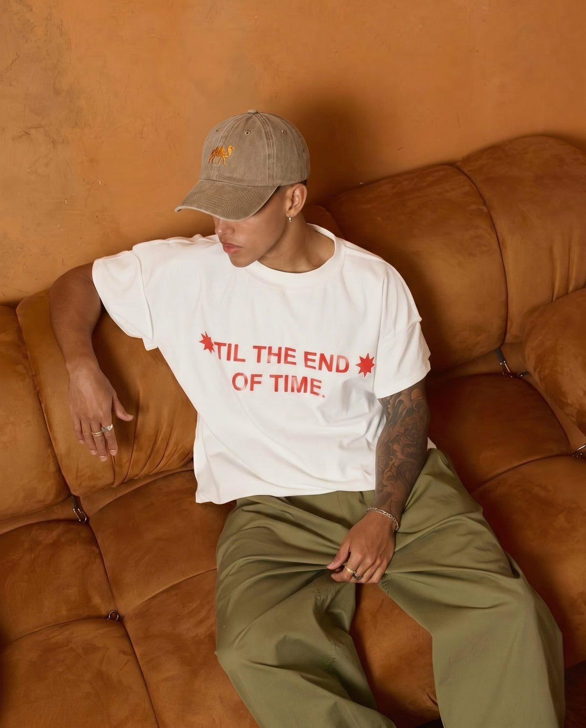 Camel embroidered cap on a bed with a tee