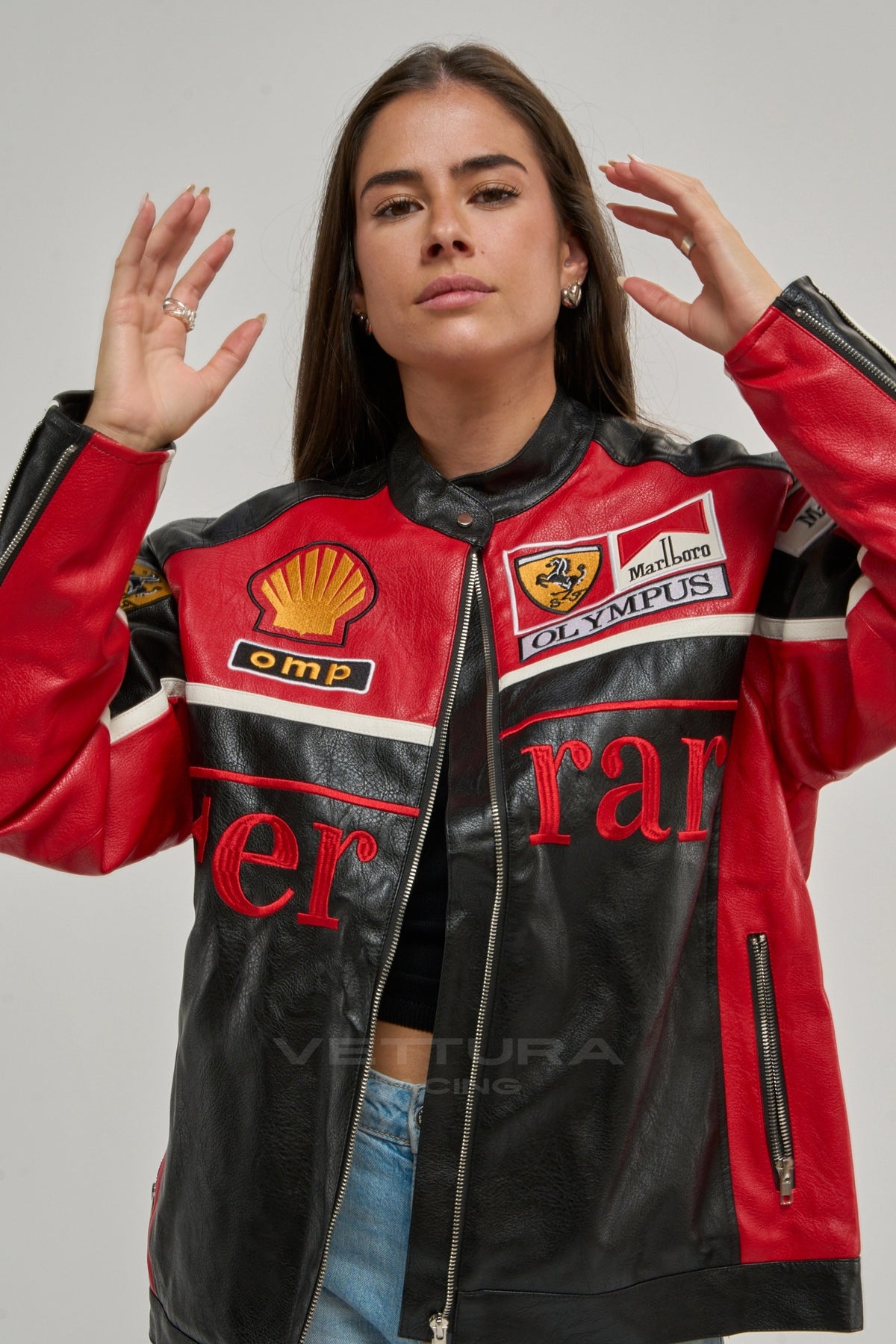 Close view of the embroidered Shell and Olympus patches on the Ferrari F1 leather jacket