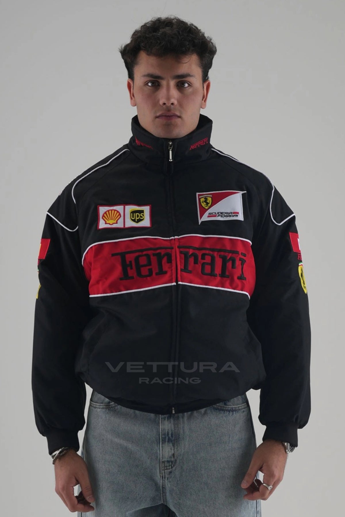 Black Ferrari F1 vintage racing jacket worn by a model, front view with the red Ferrari block and embroidered patches