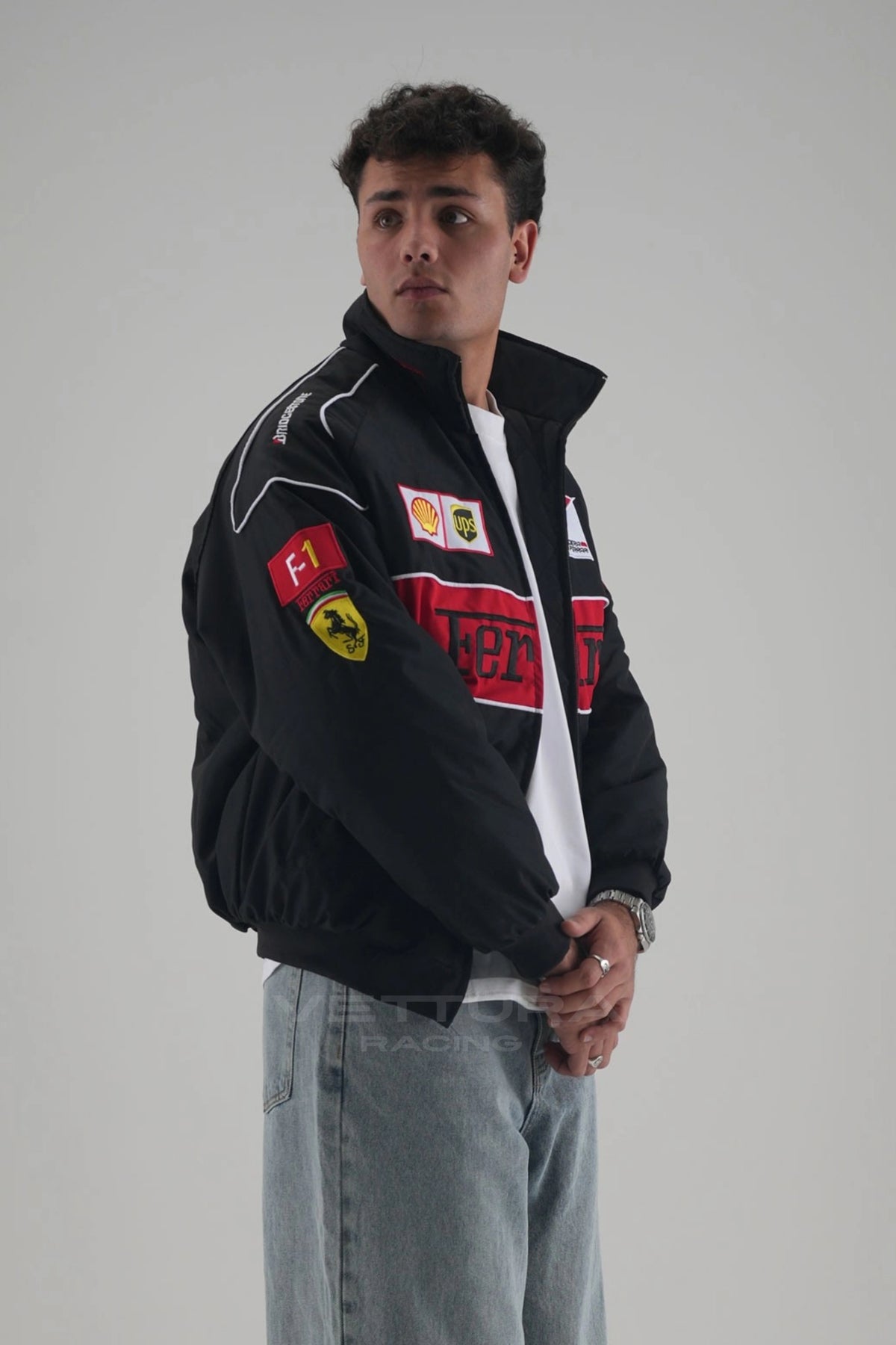 Ferrari F1 black racing bomber jacket on a model, showing the embroidered Shell and F-1 sponsor patches