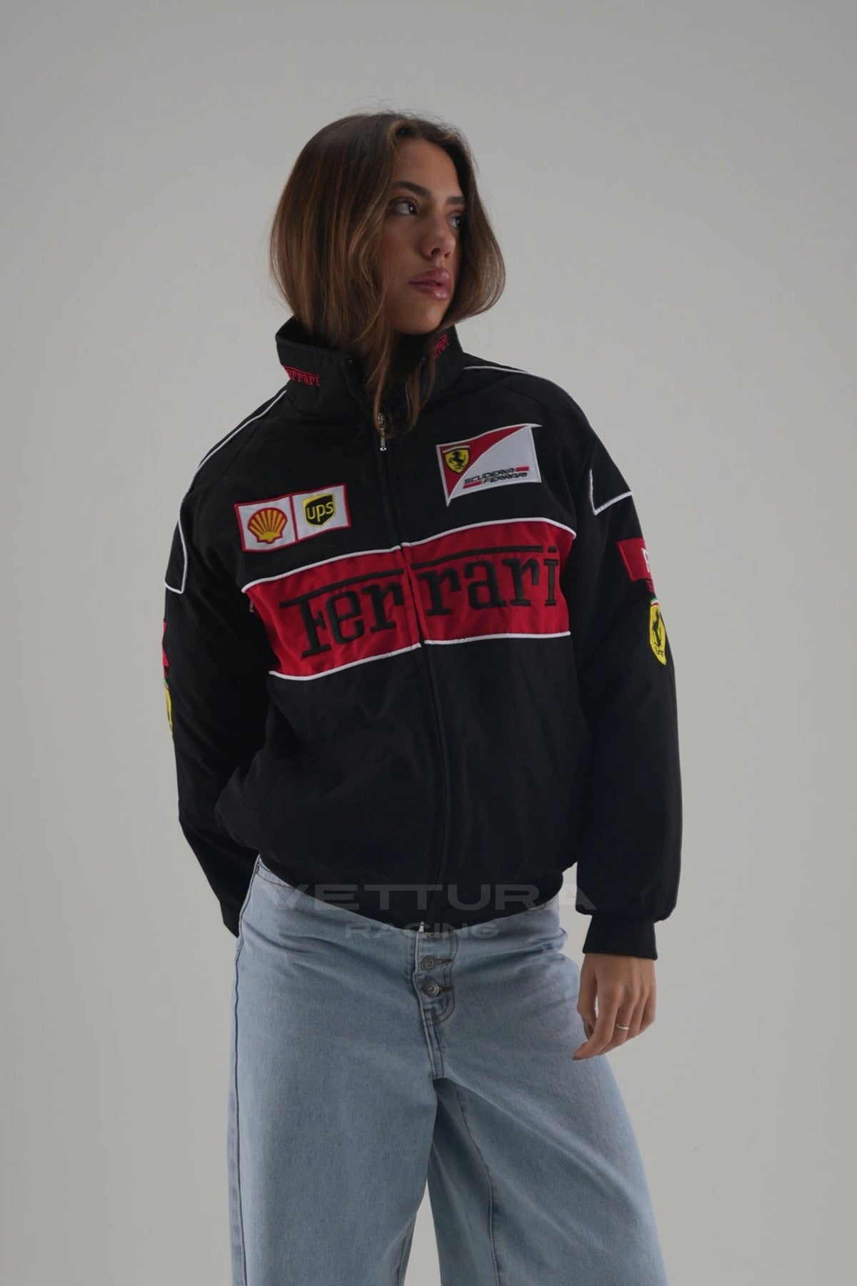 Model wearing the black Ferrari F1 padded bomber jacket, studio side view