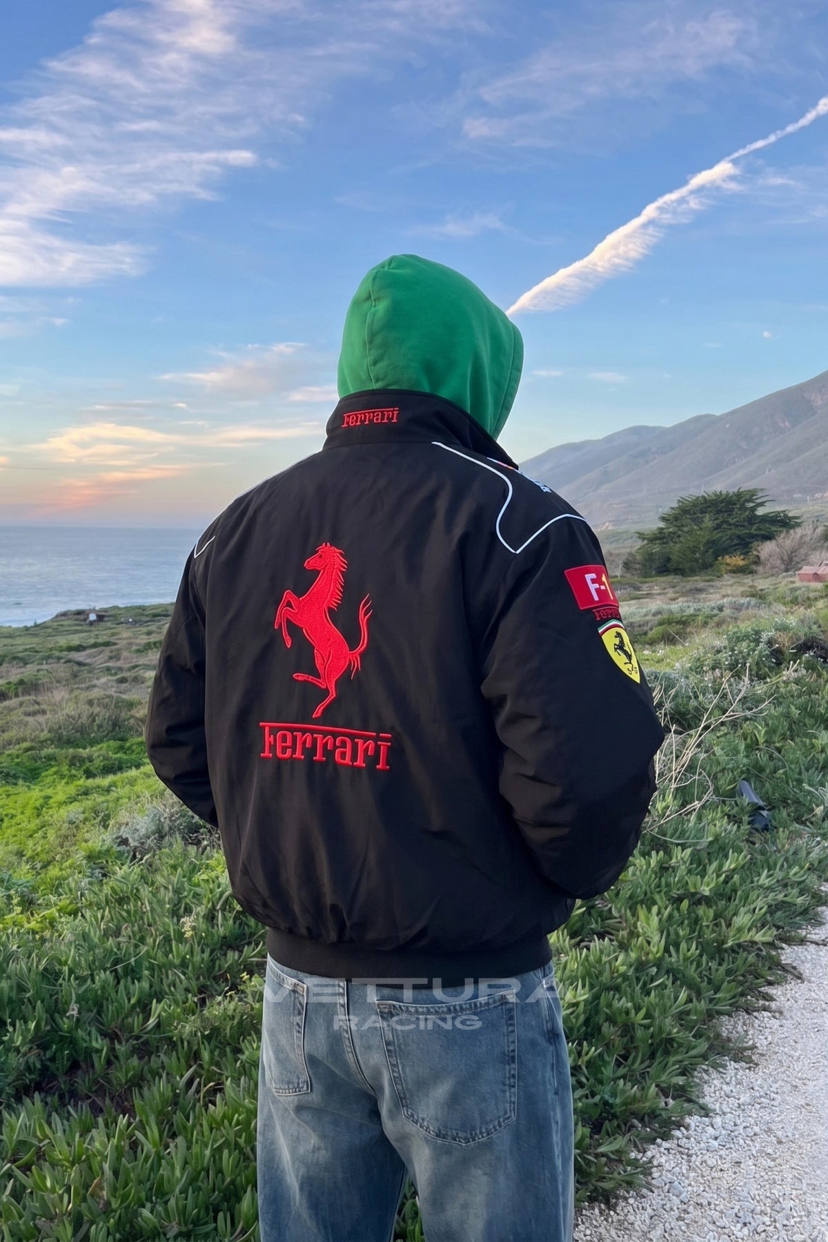 Ferrari F1 black bomber jacket worn outdoors, showing the red chest block in daylight
