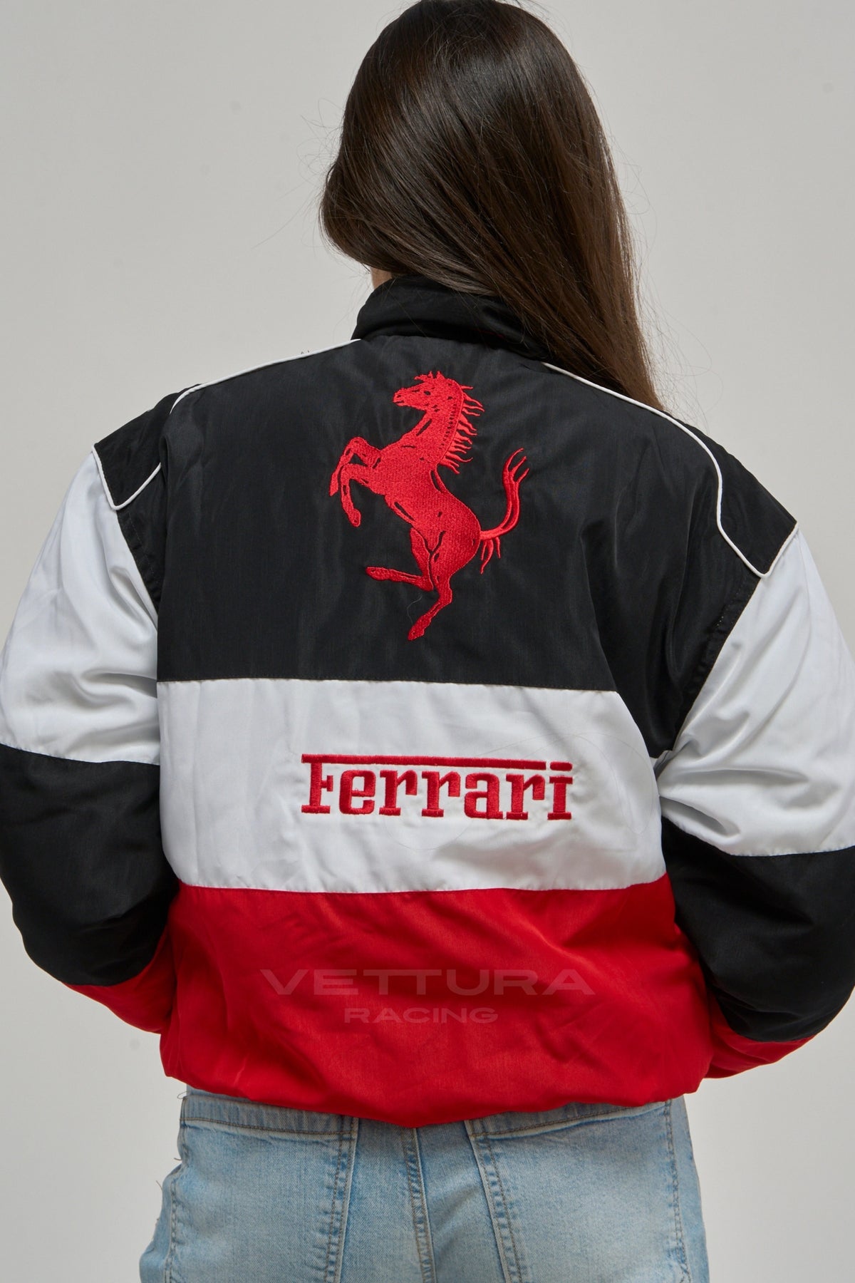 Ferrari F1 classic racing jacket photographed outdoors, showing the white chest band