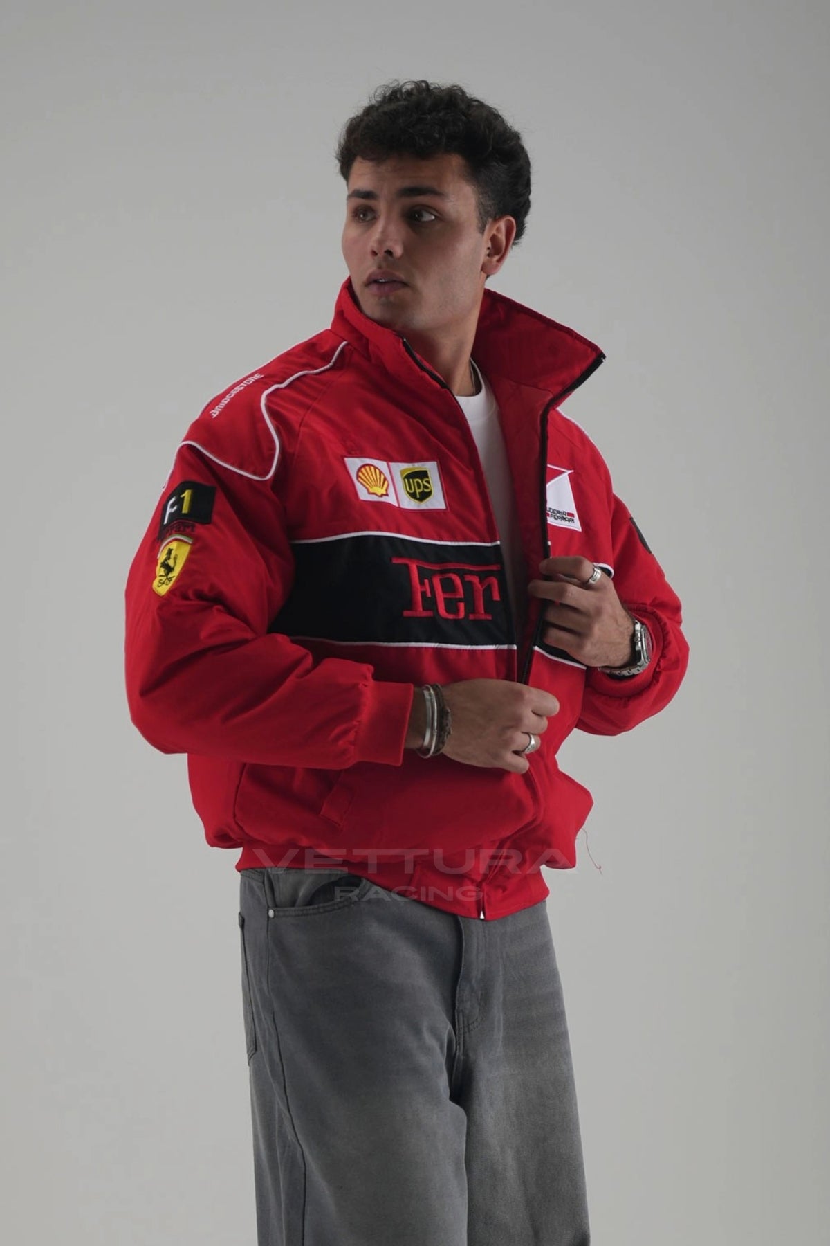 Red Ferrari F1 padded racing bomber jacket worn by a model, front view with embroidered crests