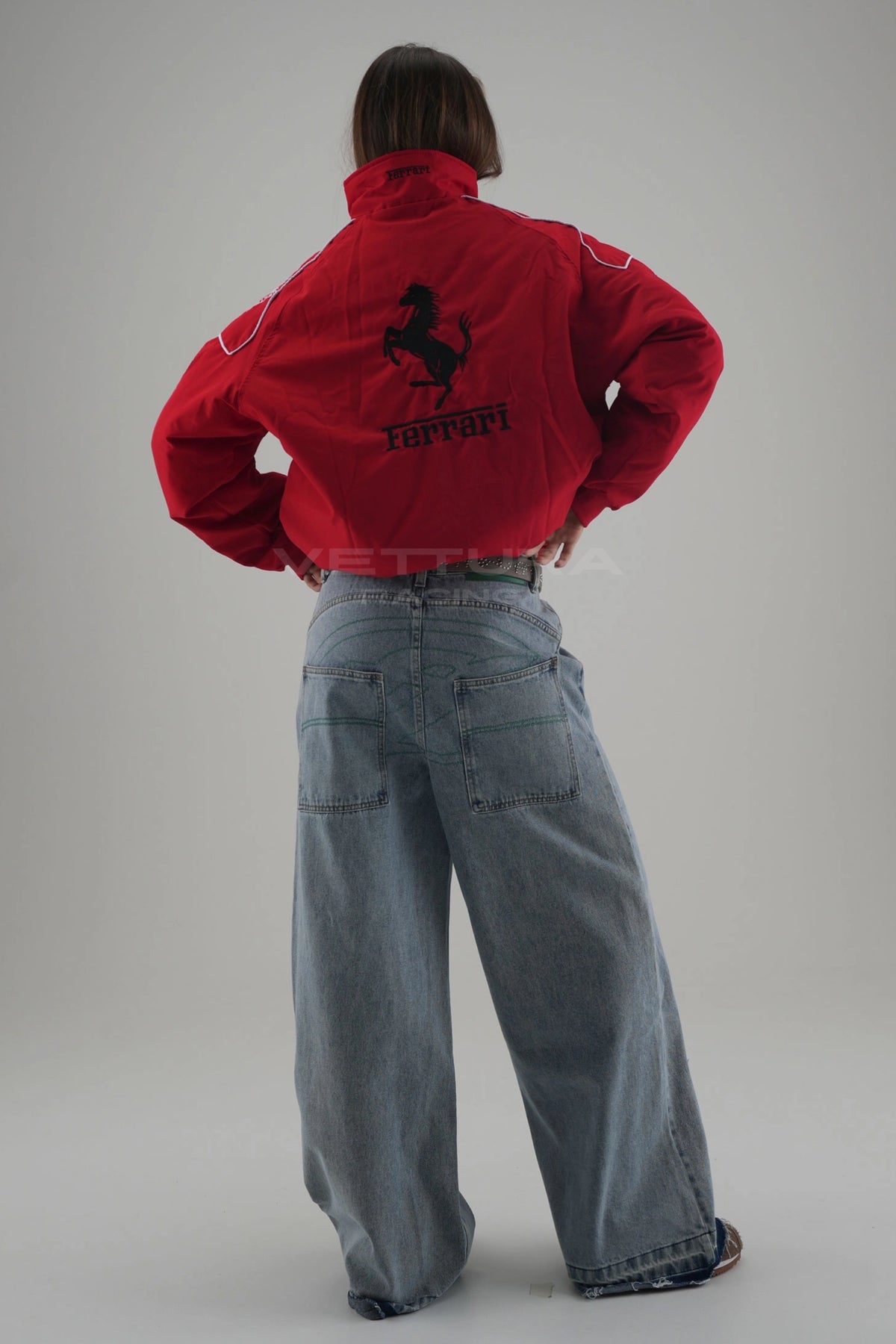 Model wearing the rosso corsa Ferrari F1 padded bomber jacket, full length studio shot