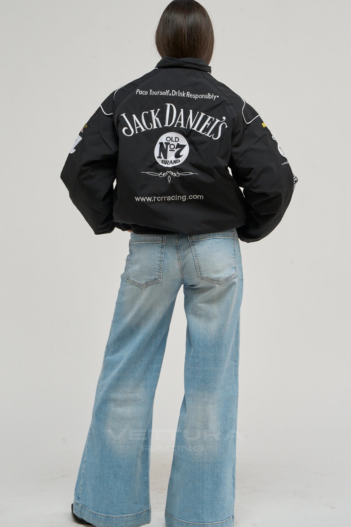 Rear view of the Jack Daniel's racing bomber worn with wide leg jeans