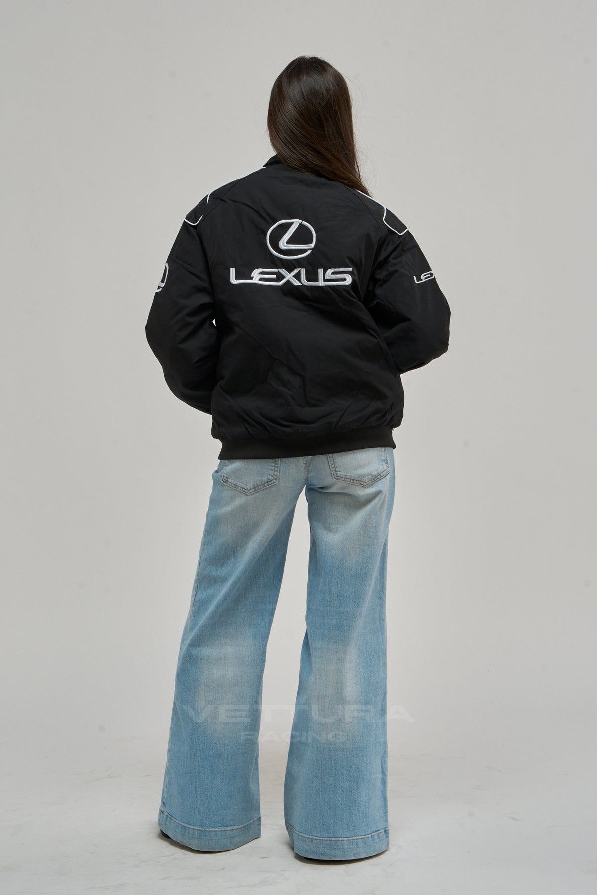 Rear view of the Lexus vintage racing jacket worn with wide leg jeans