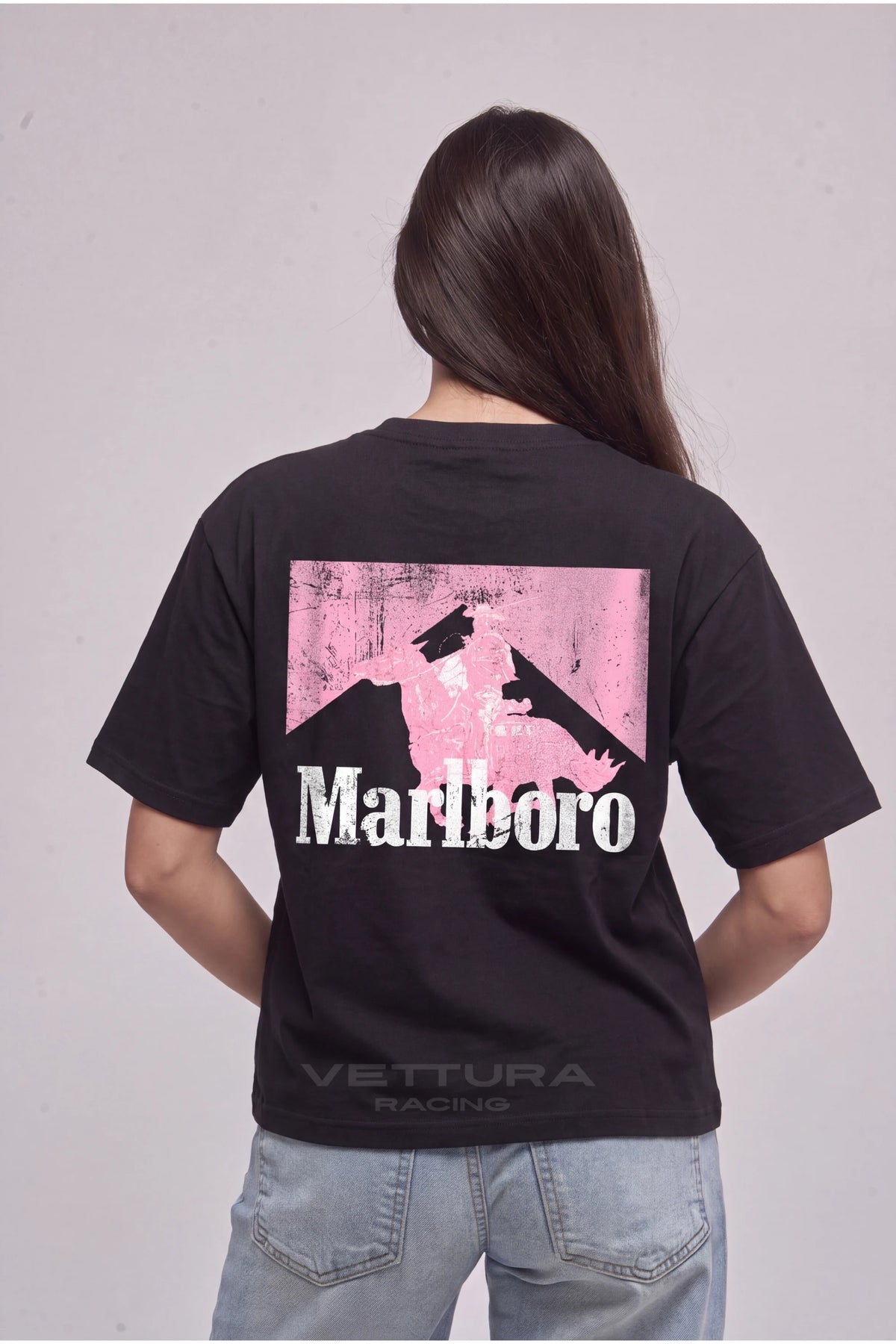 Woman wearing the Marlboro pink edition tee, back view with the pink Marlboro chevron print