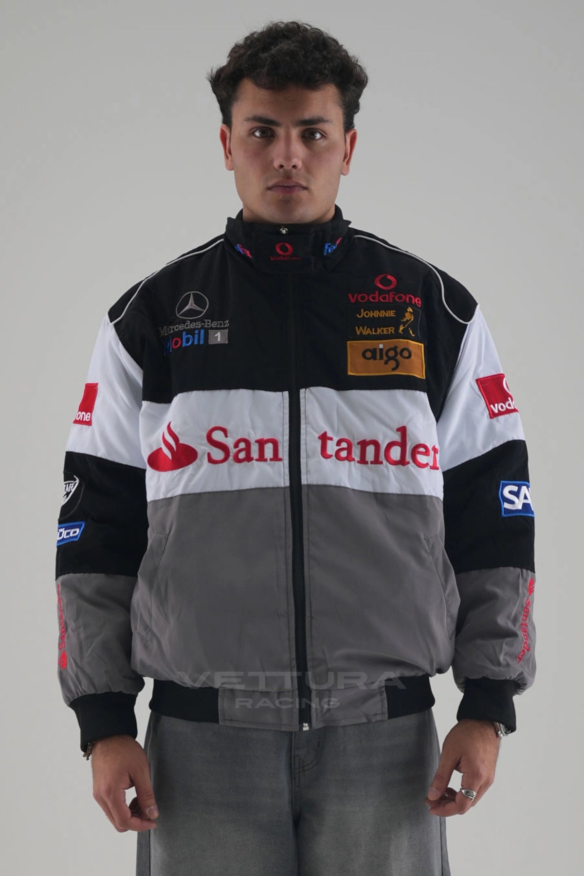 Model wearing grey and black McLaren Mercedes vintage F1 racing jacket, front view