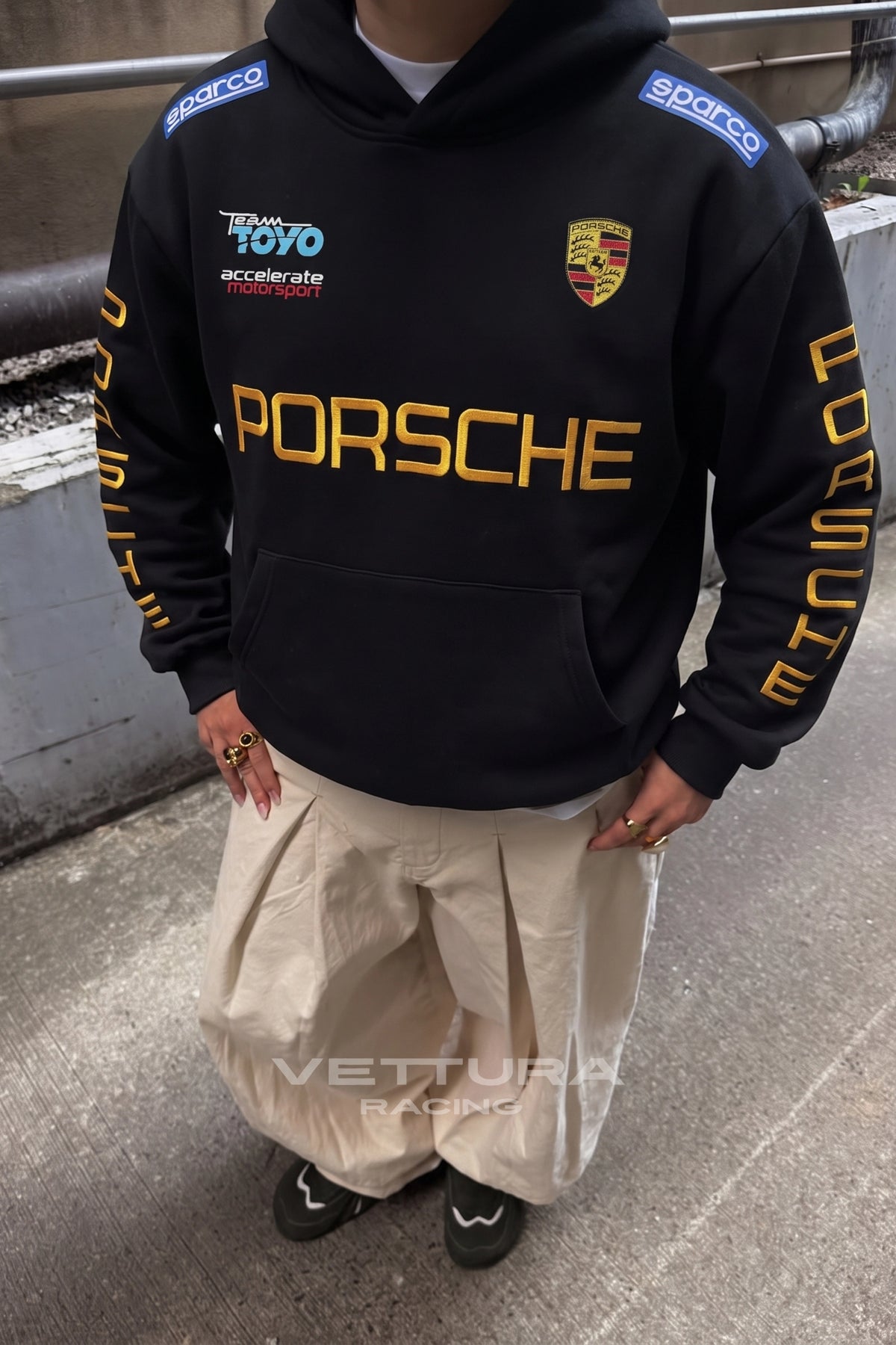 Close view of the embroidered Porsche crest on the black hoodie