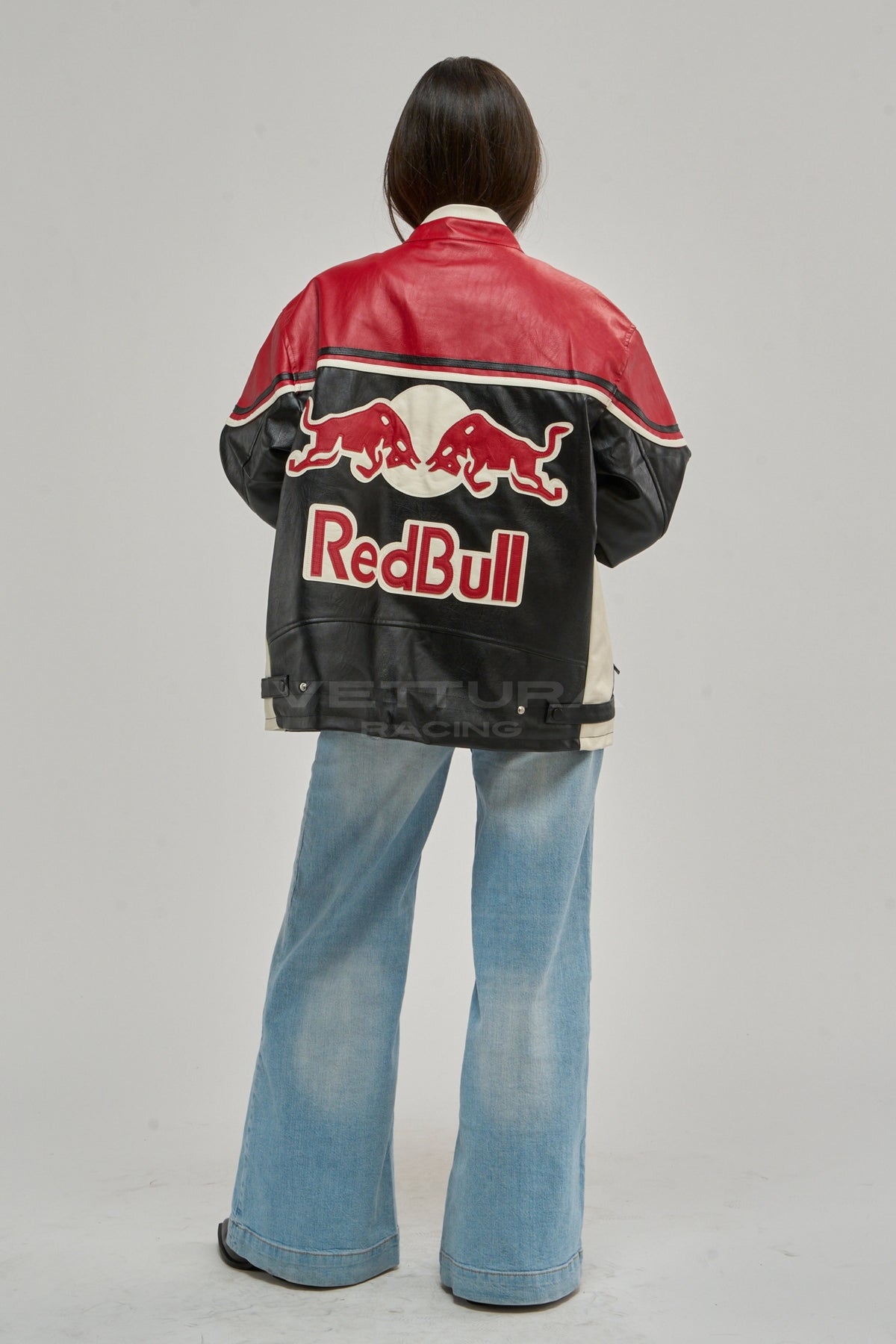 Rear view of the Red Bull leather racing jacket worn with wide jeans