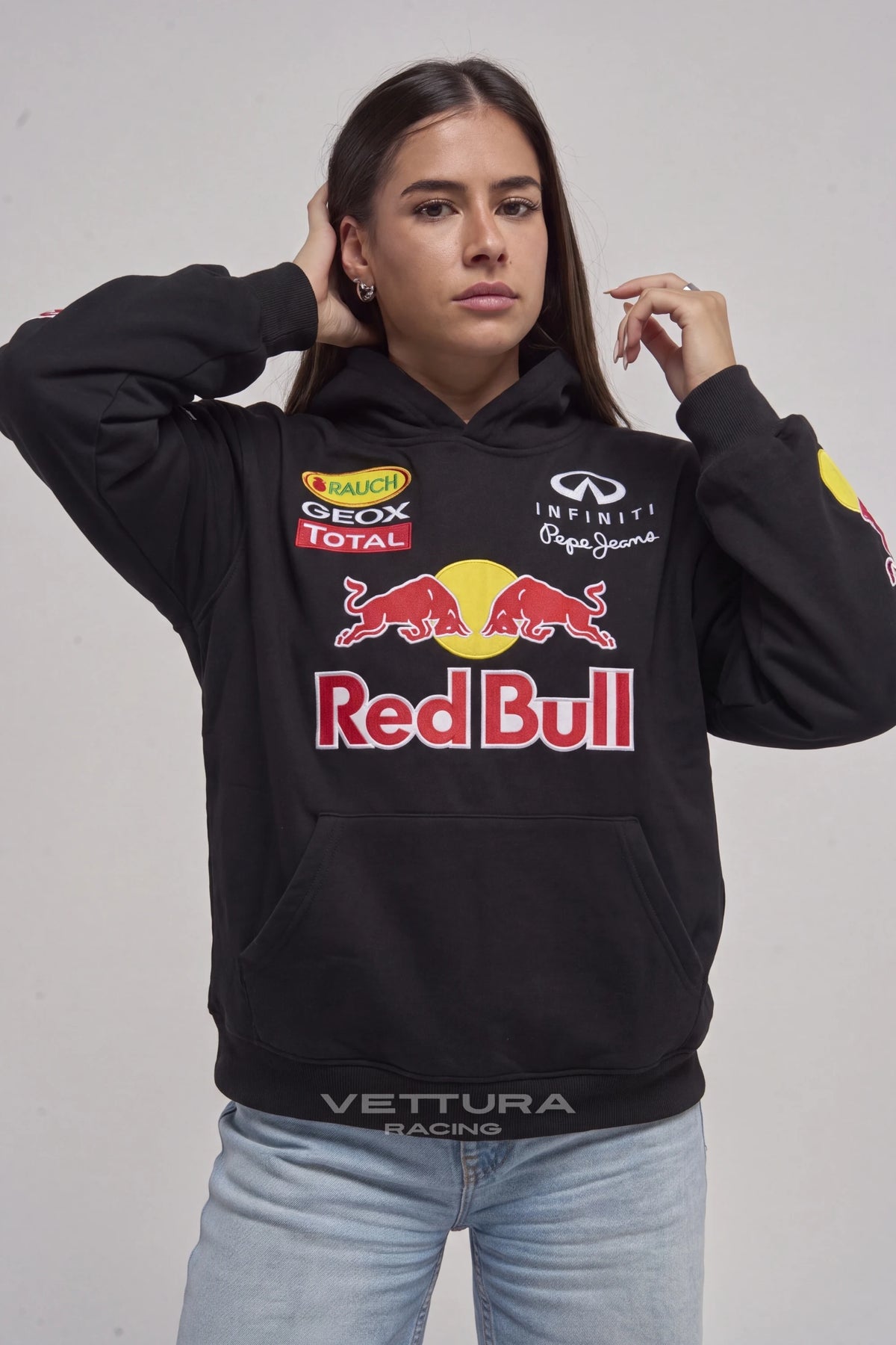 Woman wearing the Red Bull F1 embroidered hoodie, front view with the Infiniti and Total patches