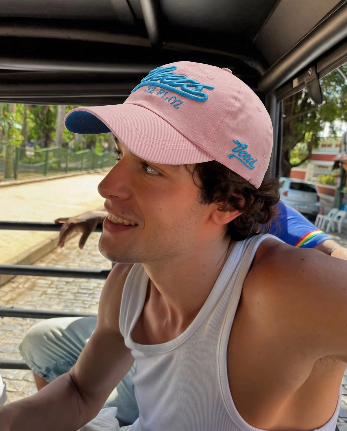 Coral pink Reese's embroidered cap worn in the sun