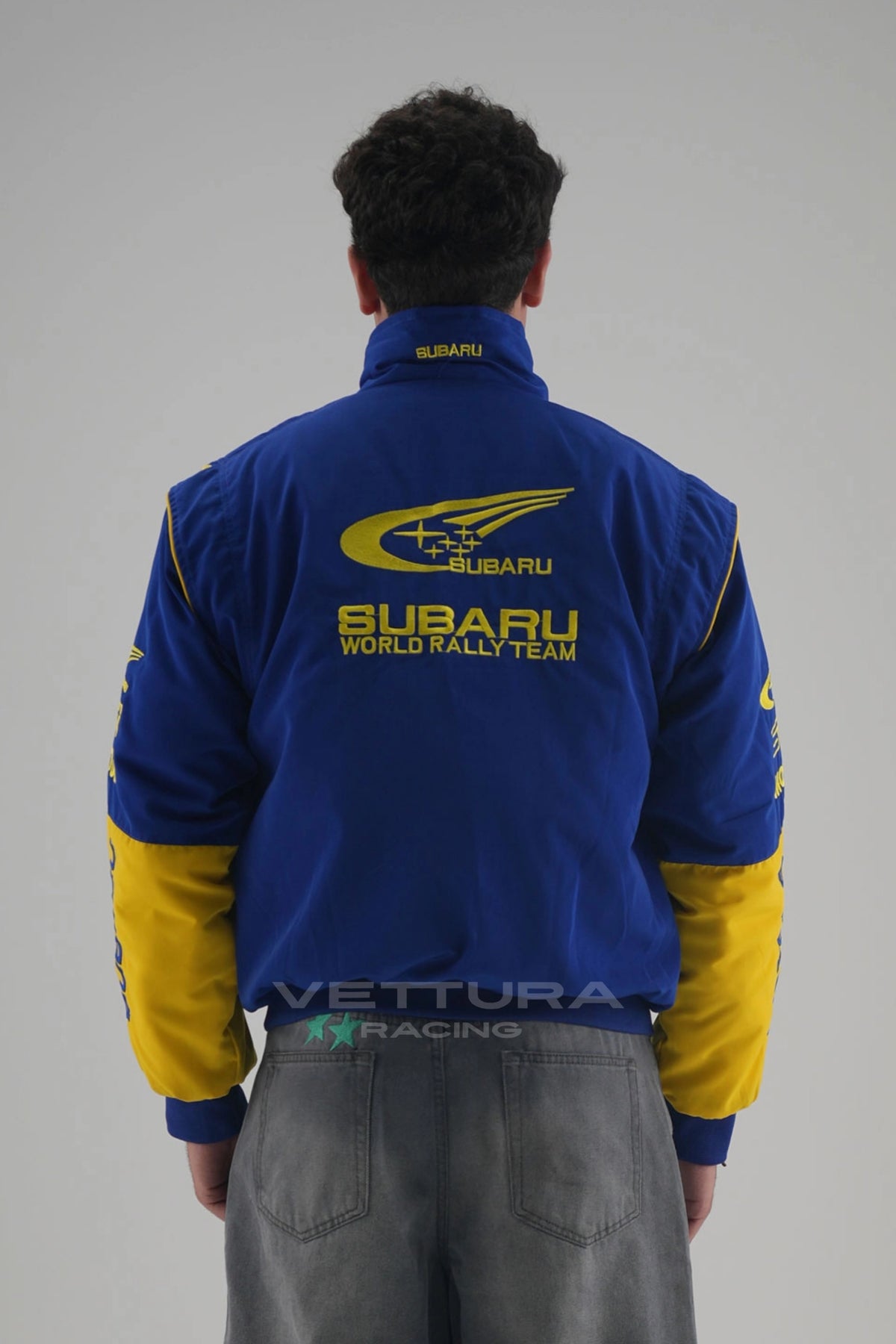 Back of the blue Subaru World Rally vintage racing jacket on a model