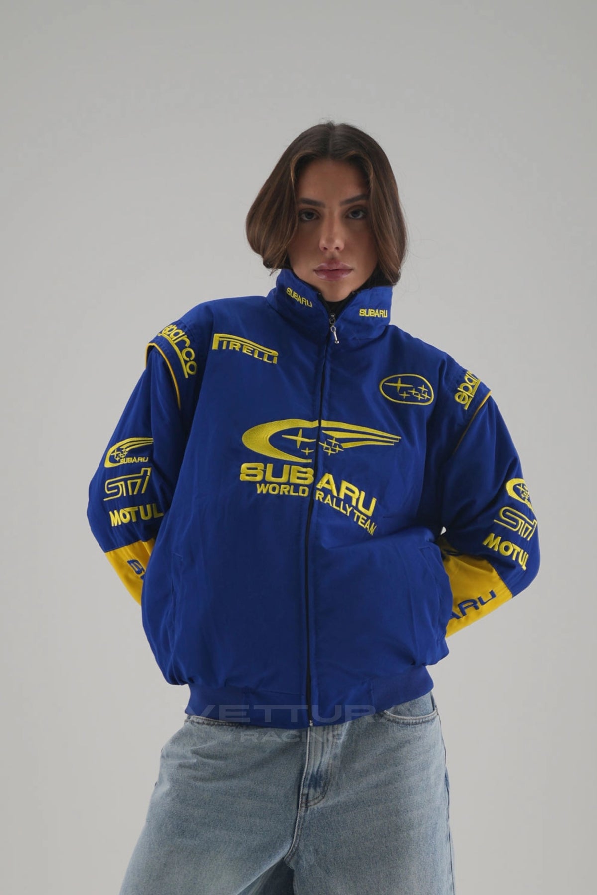 Woman wearing the blue and yellow Subaru rally vintage racing jacket