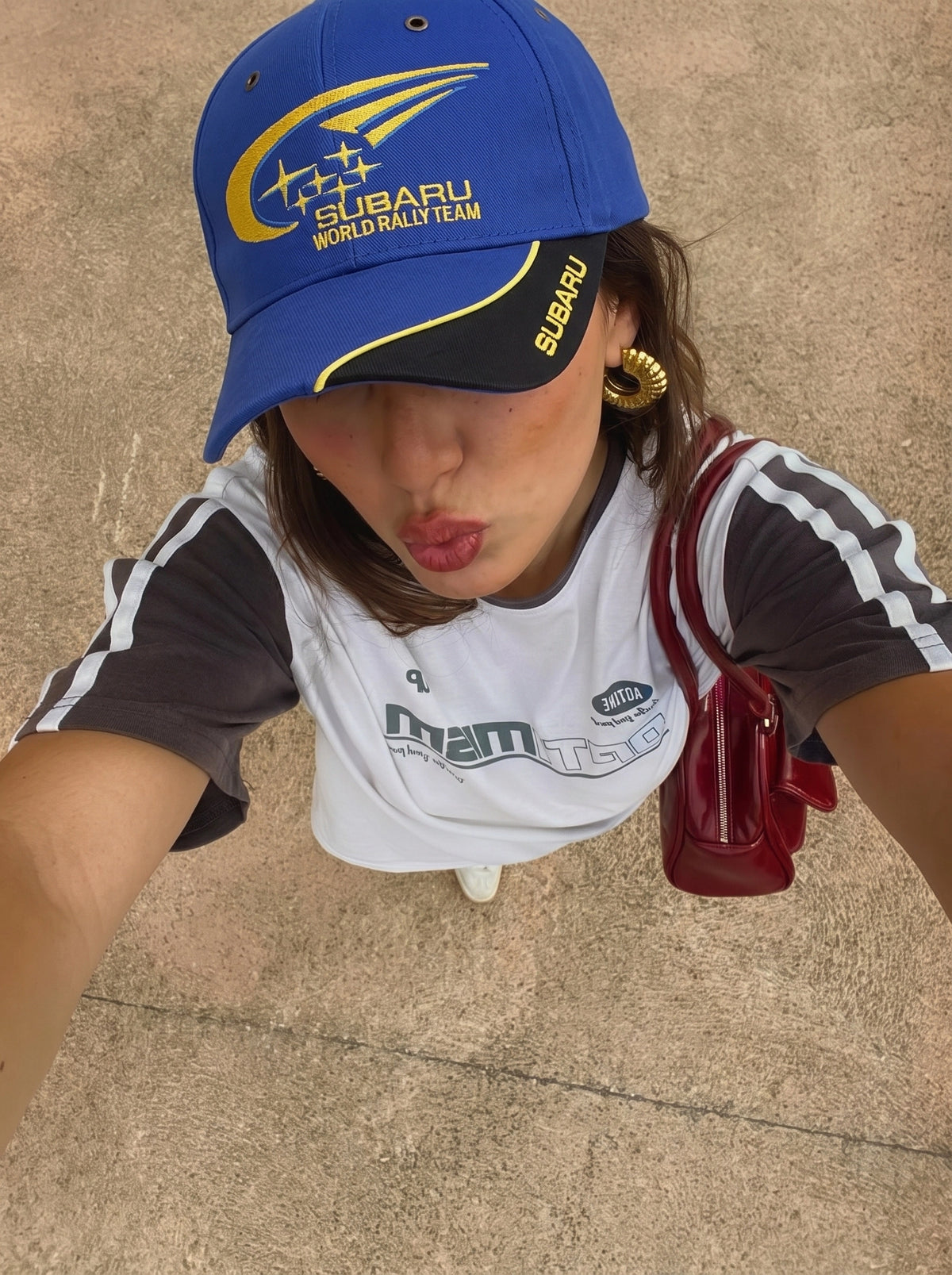 Model wearing the blue Subaru World Rally Team cap