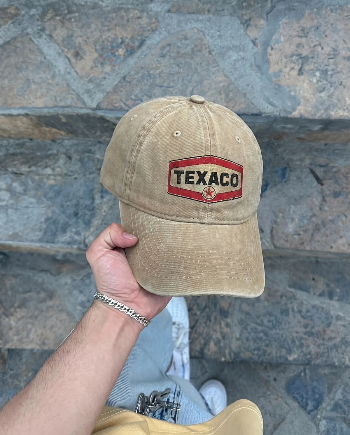 Beige Texaco Motor cap held up outdoors