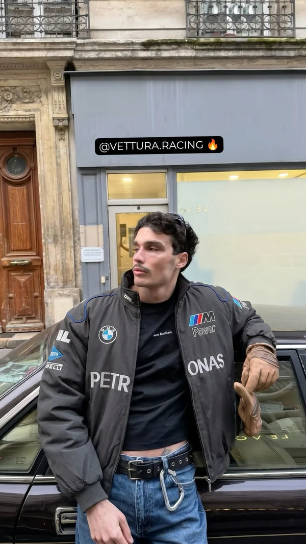 Customer in a grey BMW Petronas racing jacket next to a classic car